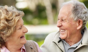 Zwei ältere Menschen schauen sich in die Augen und lachen