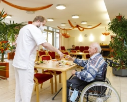Pfleger und Bewohner im Speisesaal